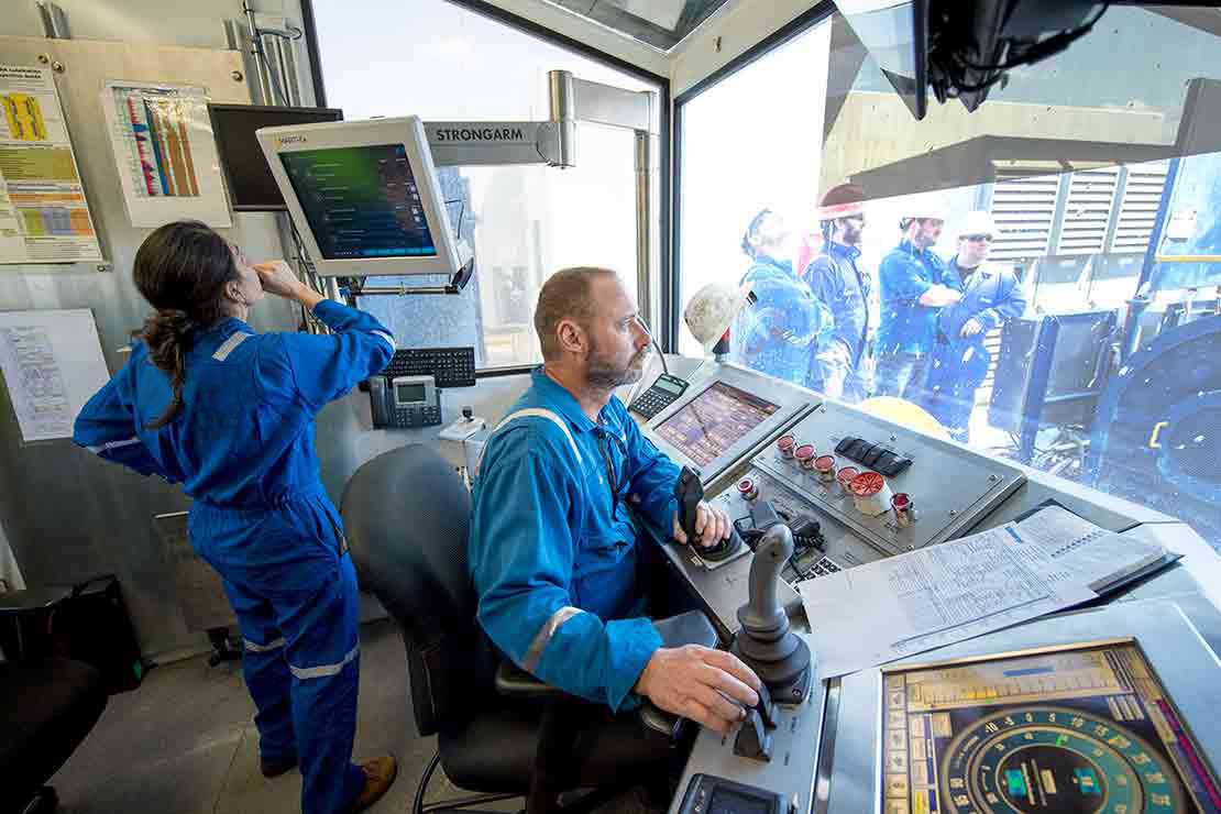 Two drilling technicians in the doghouse of a rig during daylight operations